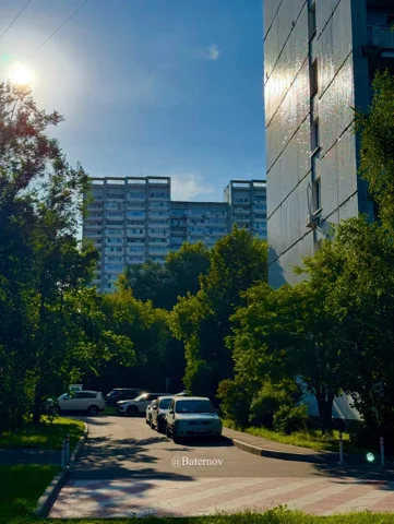 Ruhiger Wohnhof mit Bäumen und geparkten Autos