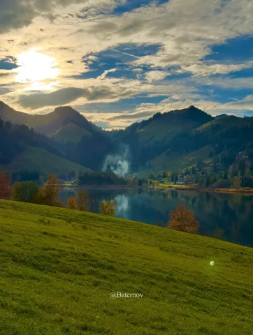 Abendsonne über See und grüner Weide