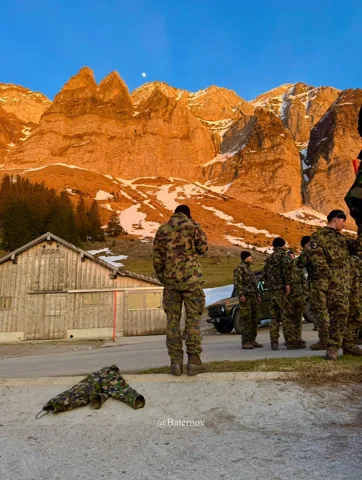Uniformierte Soldaten unter orange beleuchteten Bergfelsen