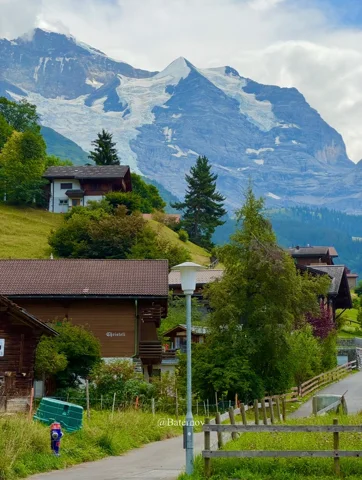 Dorfweg und Chalets unter gezackten Berggipfeln