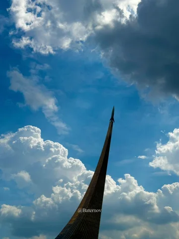 Schlankes Denkmal vor wolkenreichem Himmel