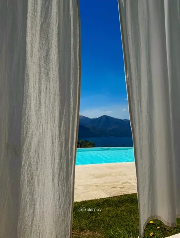 Weiße Vorhänge mit Blick auf Pool und ferne Berge