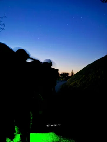 Silhouetten im Freien unter dunkler werdendem blauem Himmel