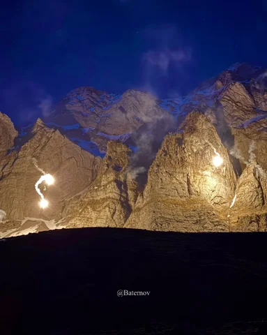 Helle Lichter vor Bergfelsen bei Nacht