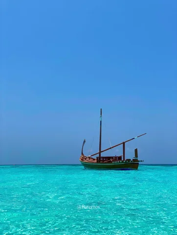 قارب تقليدي على ماء فيروزي زاهٍ