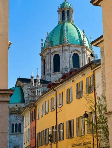 Turm mit grüner Kuppel über warmfarbigen Gebäuden