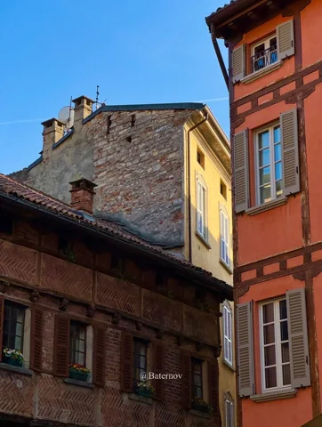 Hohe pastellfarbene Fassaden an einer schmalen Dorfgasse