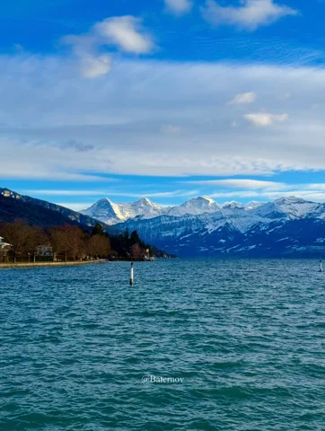 Gekräuselter See unter Schneegipfeln und blauem Himmel