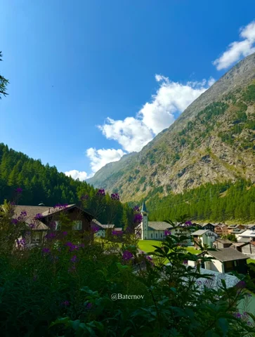 Chalets in einem schmalen Tal zwischen bewaldeten Bergen