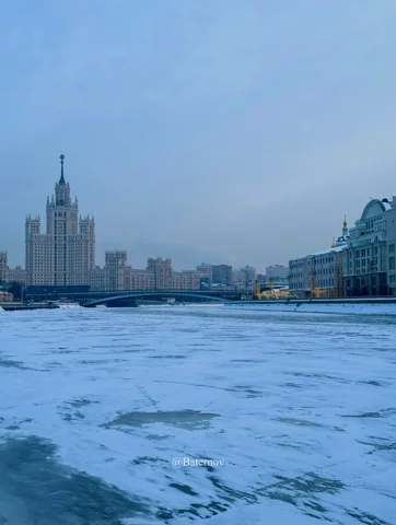 Gefrorener Fluss vor einem hohen Stadtgebäude