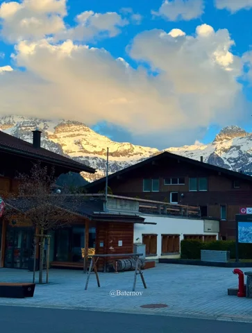 Dorfplatz unter sonnigen Schneegipfeln