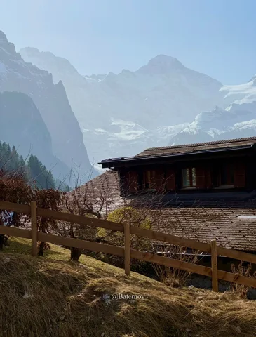 Holzgebäude unter nebligen Berggipfeln