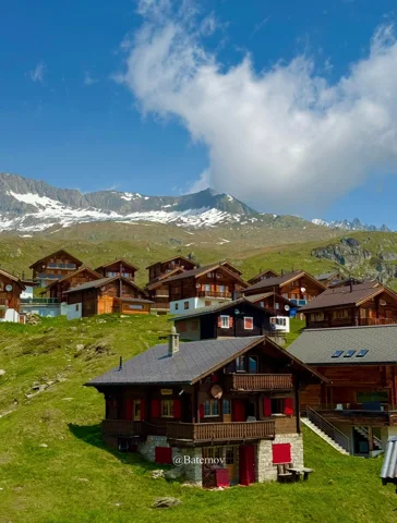 Verstreute Holzchalets auf einer Bergweide