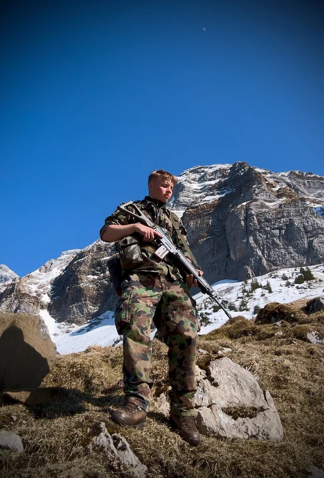 Brandon con ropa de camuflaje en una ladera rocosa.